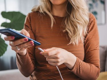 Eine Frau schließt ihr Smartphone zum Laden an
