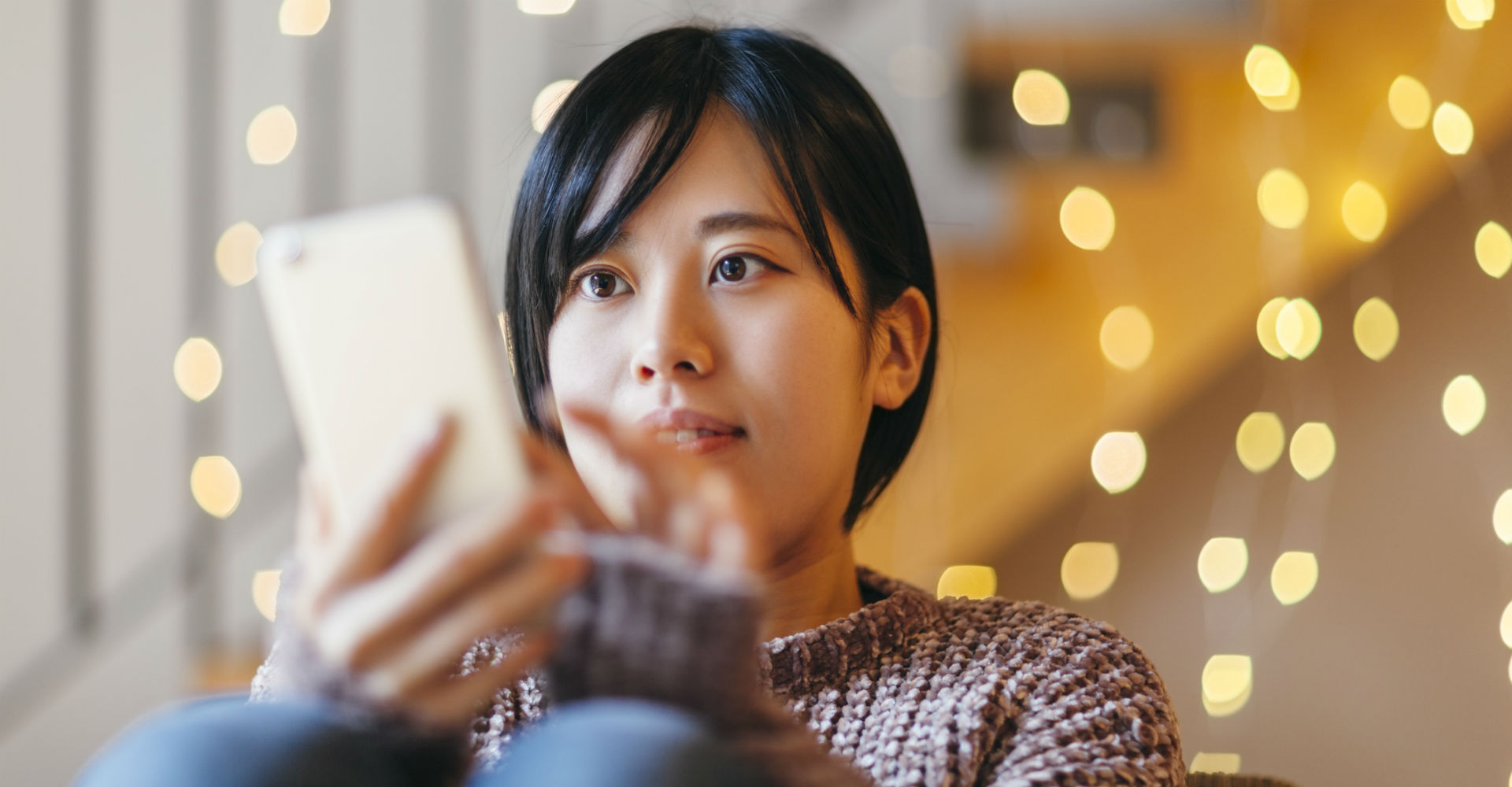 Junge Frau erhält eine Nachricht übers Smartphone.