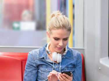 Frau mit Smartphone in der Bahn