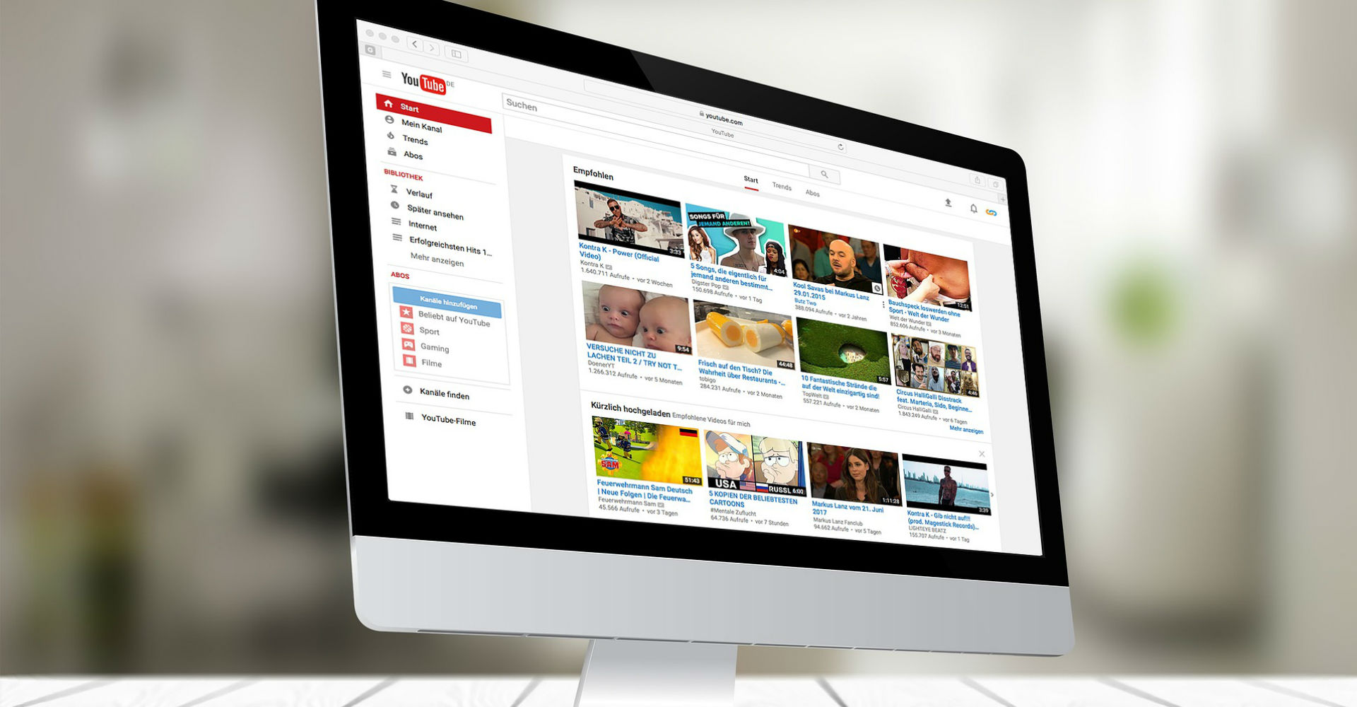 Apples weißer Mac-Computer mit YouTube im Browser geöffnet.