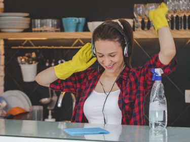 Frau mit Kopfhörern beim Putzen