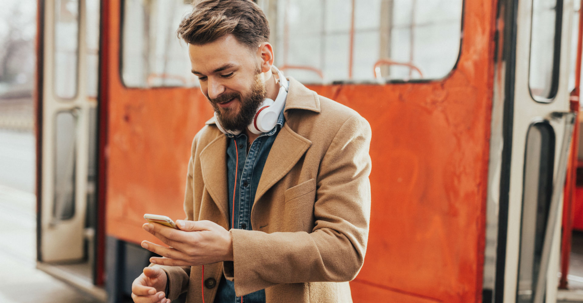 Junger Mann erhält auf dem Weg zur Arbeit eine Benachrichtigung am Smartphone.