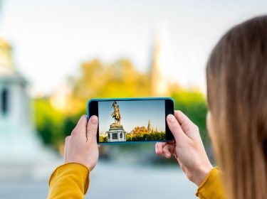 Junge Frau macht ein HDR-Foto mit dem Smartphone.