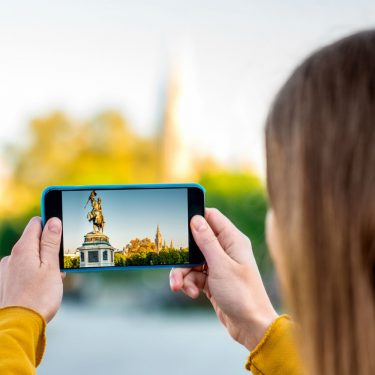 Was ist HDR? Junge Frau macht ein HDR-Foto mit dem Smartphone.