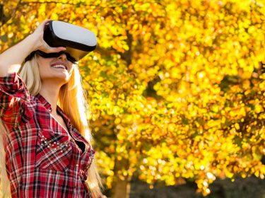 Frau im Herbst mit einer VR-Brille.