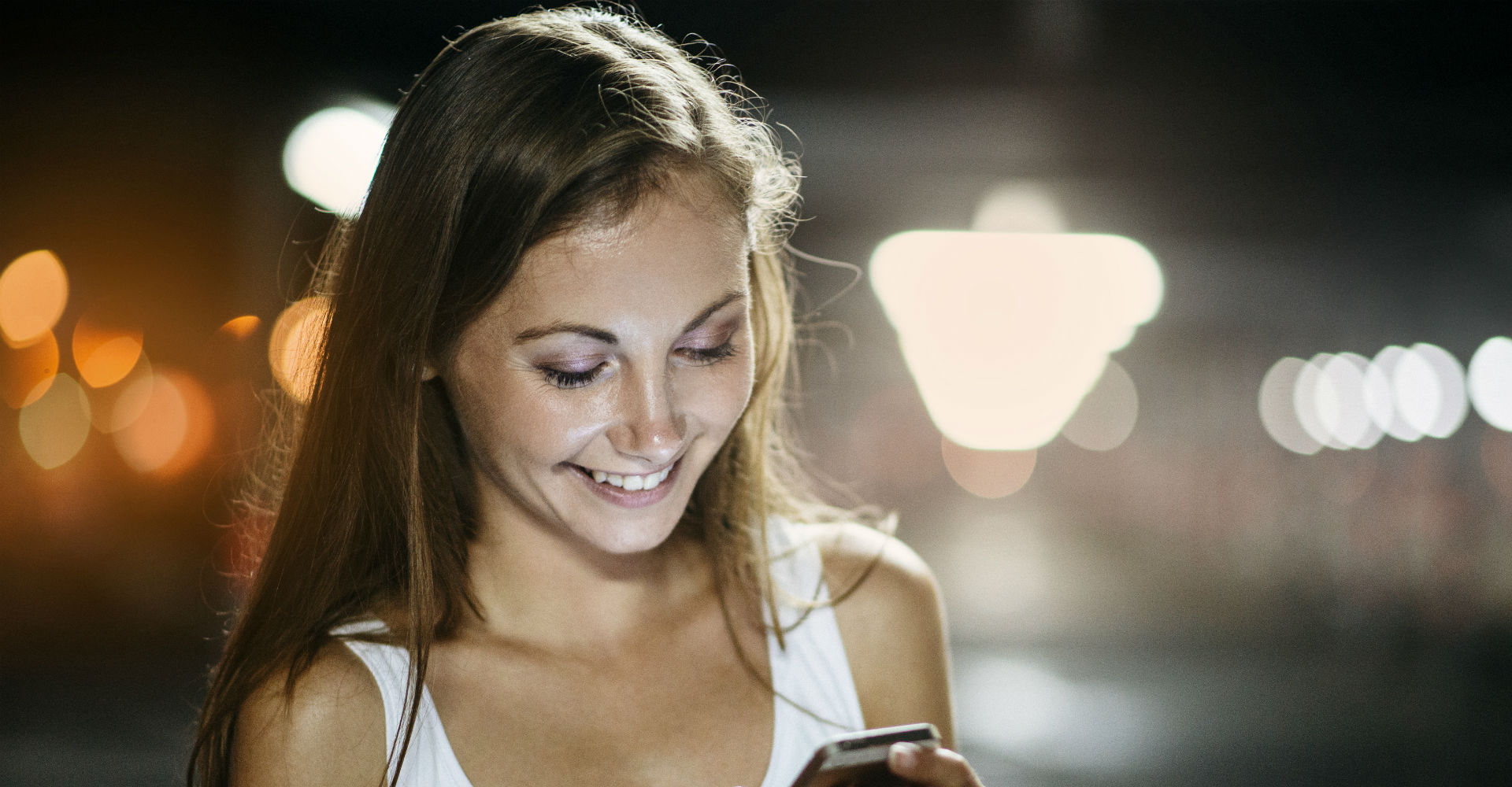 Mädchen benutzt Smartphone nachts.