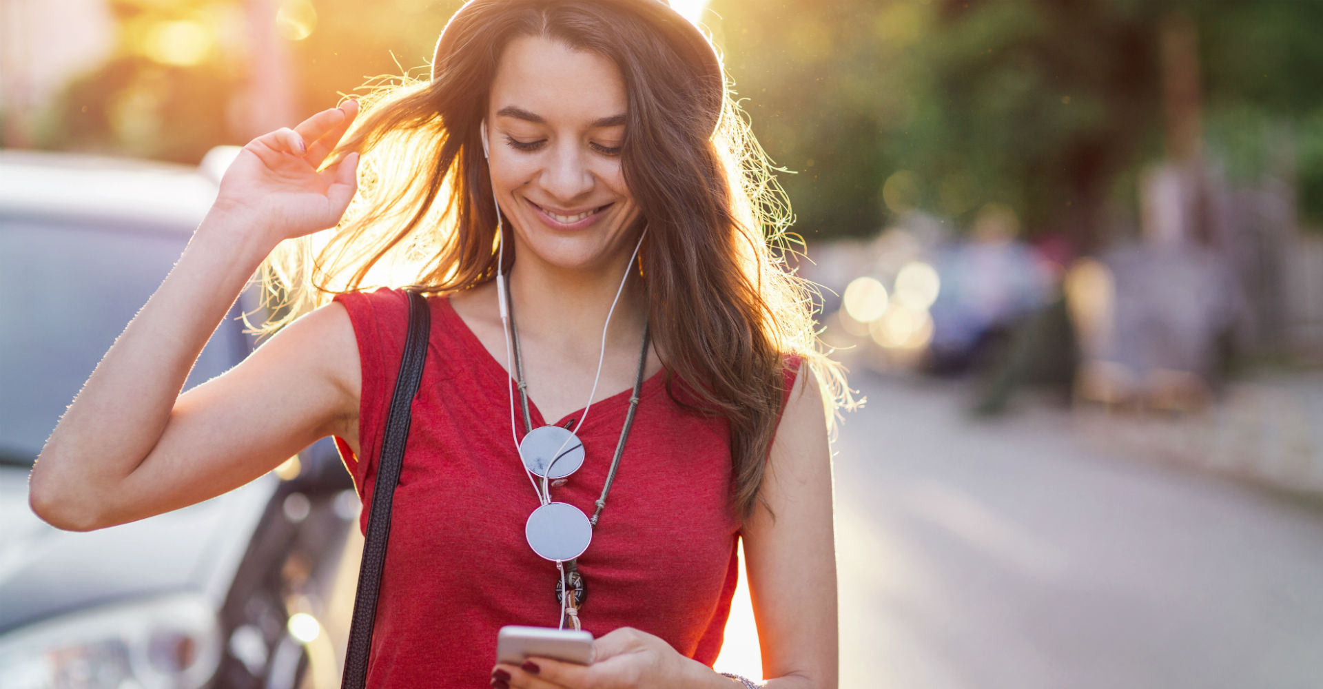 Mädchen in rotem Shirt mit Smartphone in der Hand.