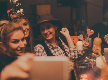 Runde junger Frauen bei einer Halloween-Party