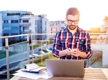 Mann schreibt auf seinem Smartphone