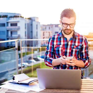 Mann schreibt auf seinem Smartphone