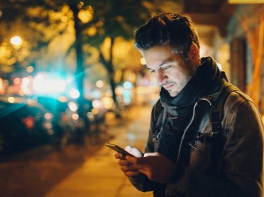 Mann schaut auf sein Smartphone-Display