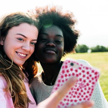 Two girls taking selfie in field_no_meta-2b