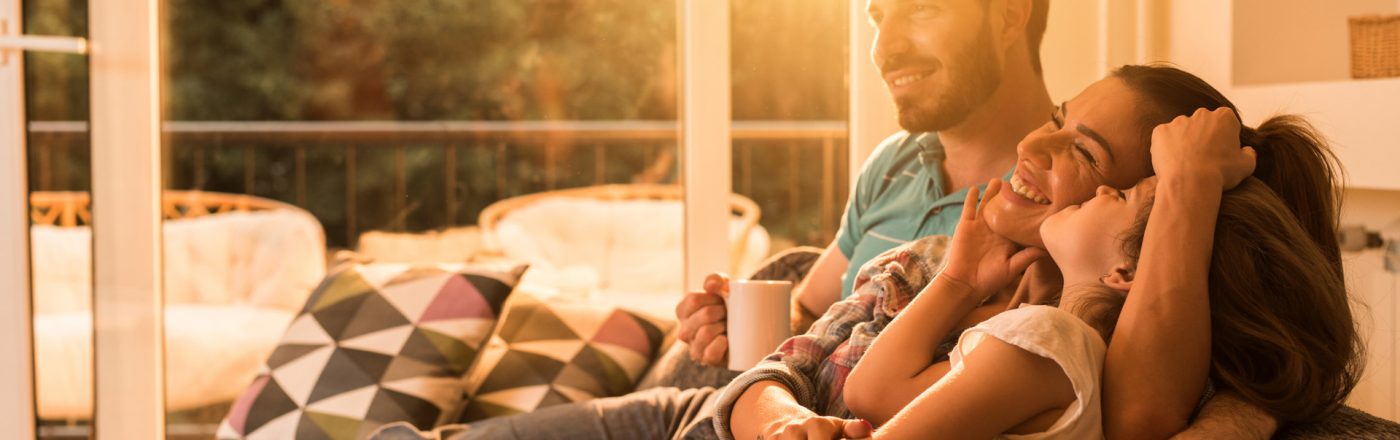 Google hat eine umfangreiche Liste mit Herstellern für kompatible Smart Home-Geräte veröffentlicht Glückliche Familie auf dem Sofa im smarten Zuhause
