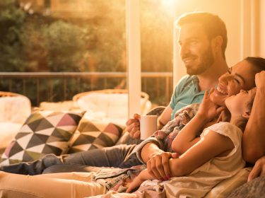 Glückliche Familie auf dem Sofa im smarten Zuhause