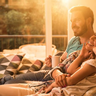 Google hat eine umfangreiche Liste mit Herstellern für kompatible Smart Home-Geräte veröffentlicht Glückliche Familie auf dem Sofa im smarten Zuhause