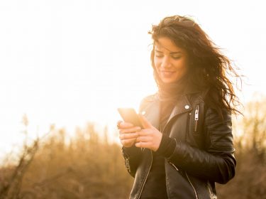 Junge Frau textet am Smartphone.