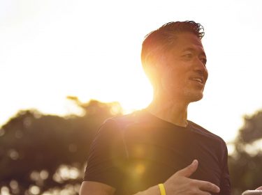 Mann sieht sich Akku-Ladestand seines Smartphones an.