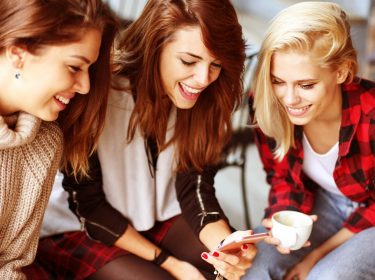 Gruppe von drei Frauen mit Smartphone
