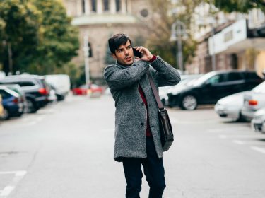 Junger Mann telefoniert dank SIM-Karte in seinem Smartphone.