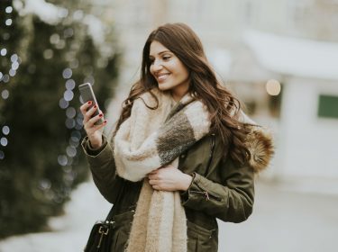 Junge Frau aktualisiert ihr Smartphone.