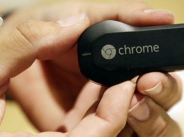 Den Google Chromecast in der Hand halten.