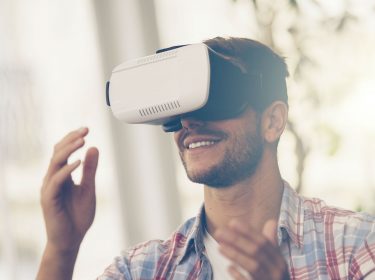 Junger Mann schaut einen Film über seine VR-Brille.