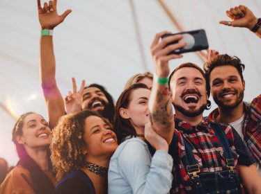 Junge Leute machen Selfies auf einem Festival