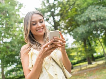 Junge Frau spielt ein Adventure-Game auf ihrem Smartphone.