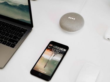 Google Smart Home Mini, ein Laptop und ein Smartphone