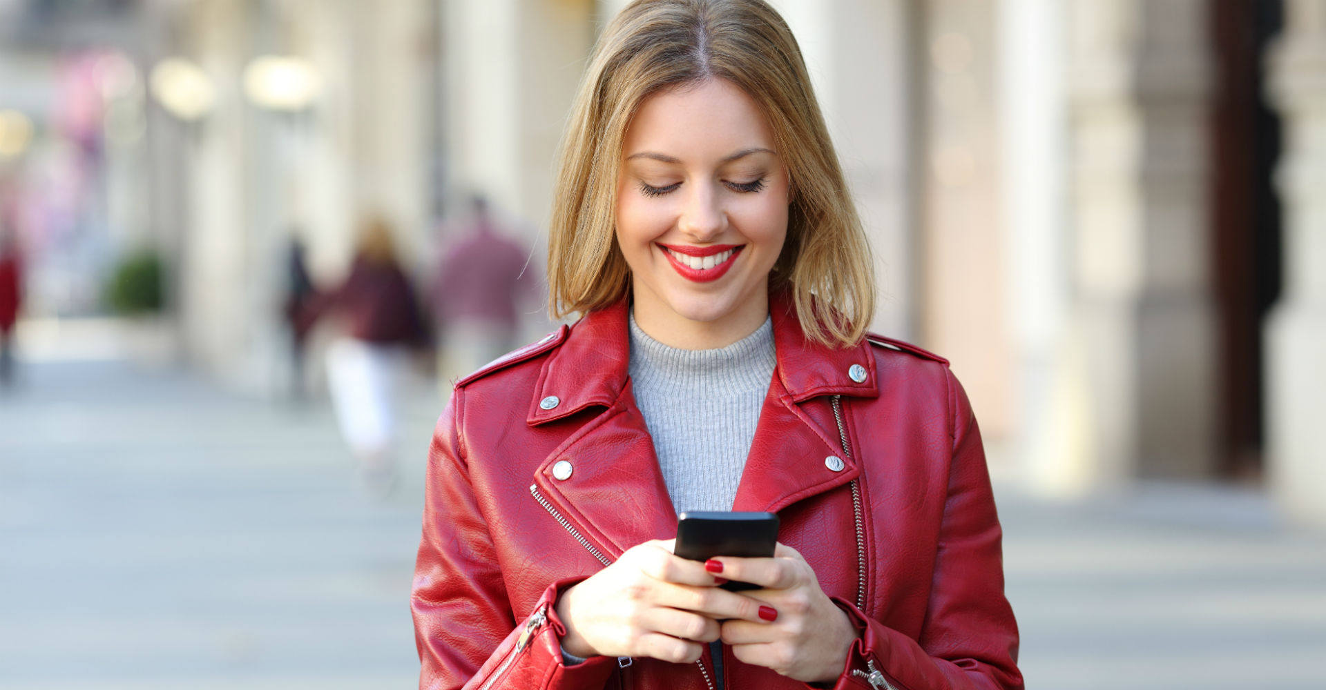 Junge Frau schreibt eine WhatsApp-Nachricht an ihrem Smartphone.