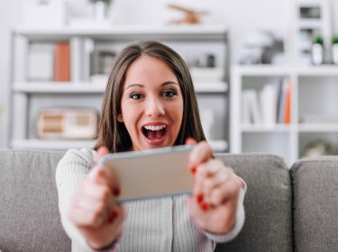 Eine Frau steuert ein Spiel via Smartphone