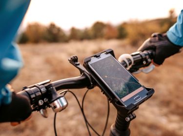 Radfahrer nutzt Fahrrad-Navi-App am Handy.