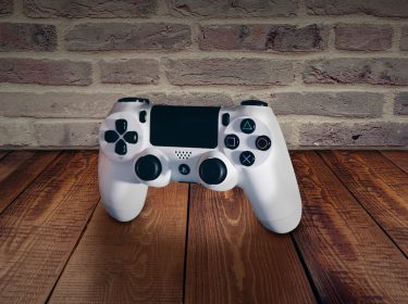 PlayStation 4-Controller schwebt über einem Tisch aus Holz.