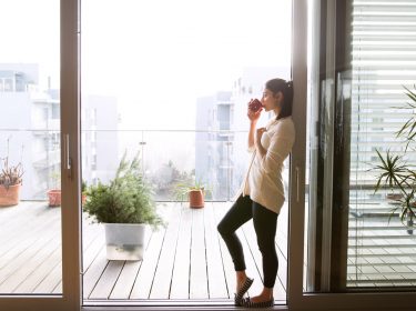 Eine Frau trinkt Kaffee am Balkon