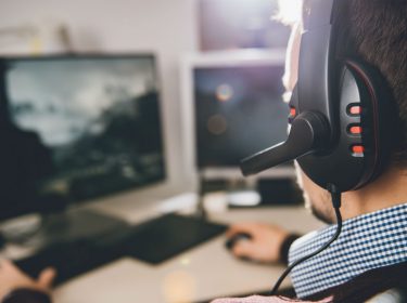 Junger Mann spielt die PC-Fassung von Final Fantasy XV am Computer.