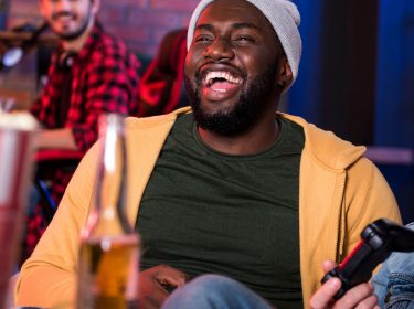 Junge Männer spielen SIMS 4 an der PS4.