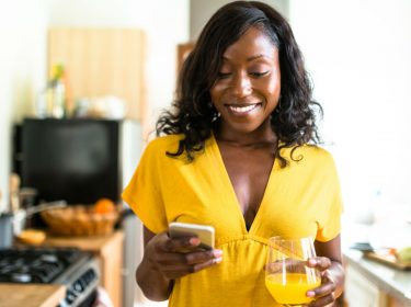 Junge Frau spielt Final Fantasy XV am Smartphone.