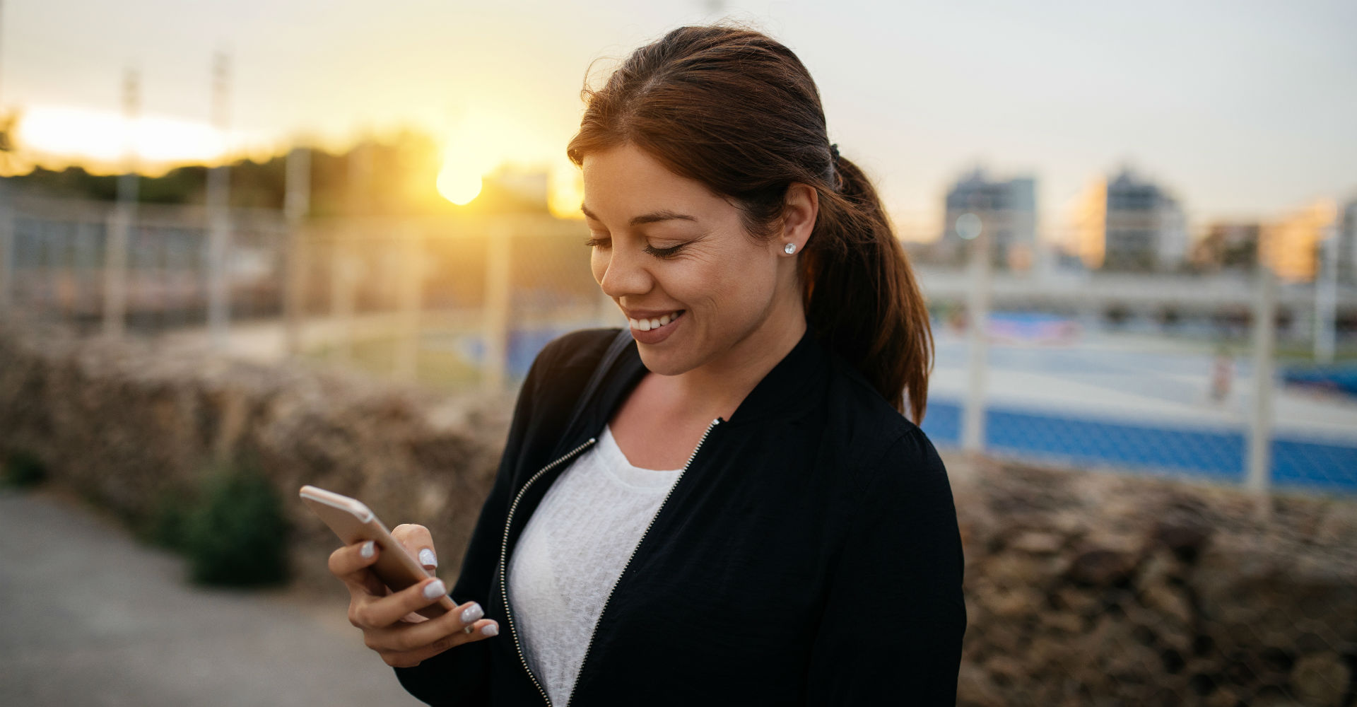 Junge Frau schreibt E-Mail an ihrem Smartphone.