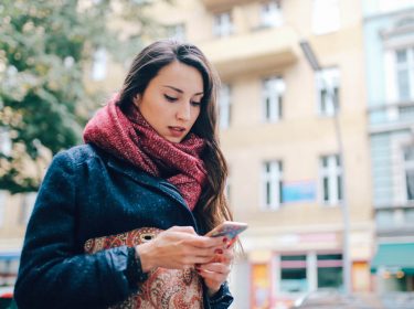 Eine Frau mit Smartphone in der Stadt