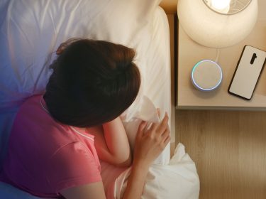 Frau stellt den Wecker ihres Amazon Echo Dots.