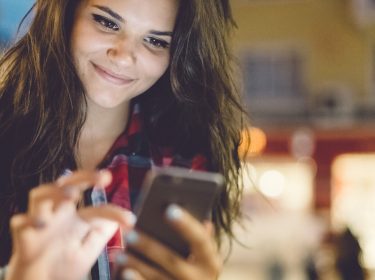 Junge Frau nutzt Twitter auf dem Smartphone