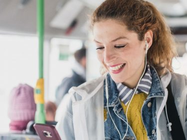 Junge Frau taggt eine Freundin in Snapchat auf ihrem Smartphone.