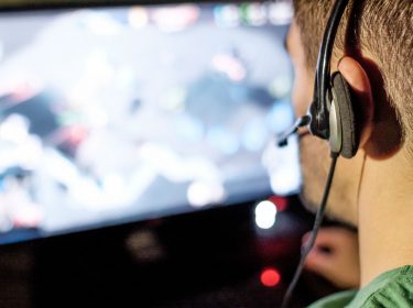 Mann zockt am Computer seine PC-Spiele.