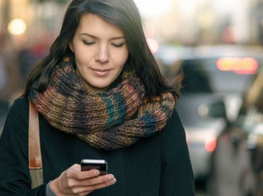 Junge Frau nutzt den Google Kalender auf ihrem Smartphone.