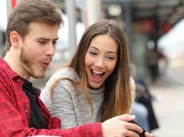 Junges Paar bewundert Android P auf dem Smartphone.