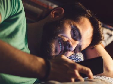 Junger Mann steuert Siri via Spracheingabe