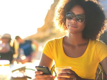 Junge Frau checkt Android Excellence-Gewinner am Smartphone.