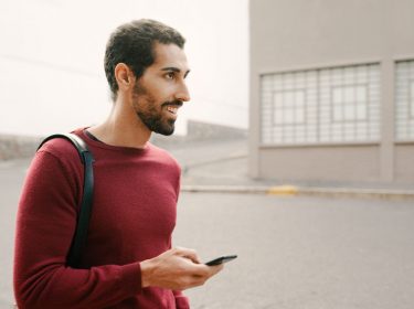 Junger Mann aktiviert App Drawer auf seinem Smartphone.
