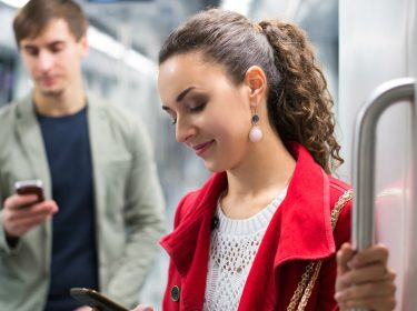 Junge Frau schaut Instagram-Fotos auf dem Smartphone an.