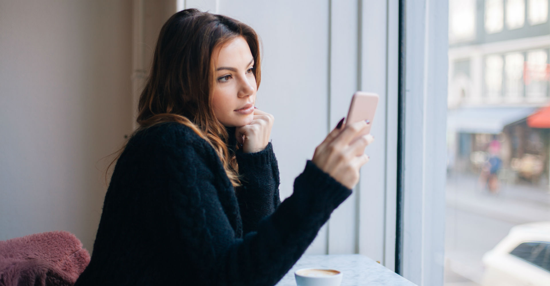 Junge Frau ändert die Einstellungen von Instagram auf ihrem Smartphone.